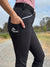 Close up showing a woman wearing the bootleg riding pants with her hand in the phone pocket.