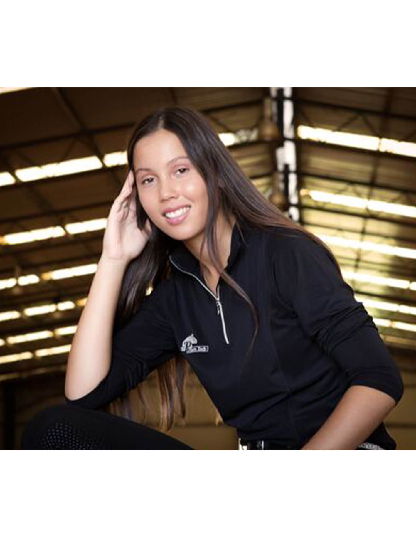 Woman wearing long sleeve summer riding top, sleeves pushed up