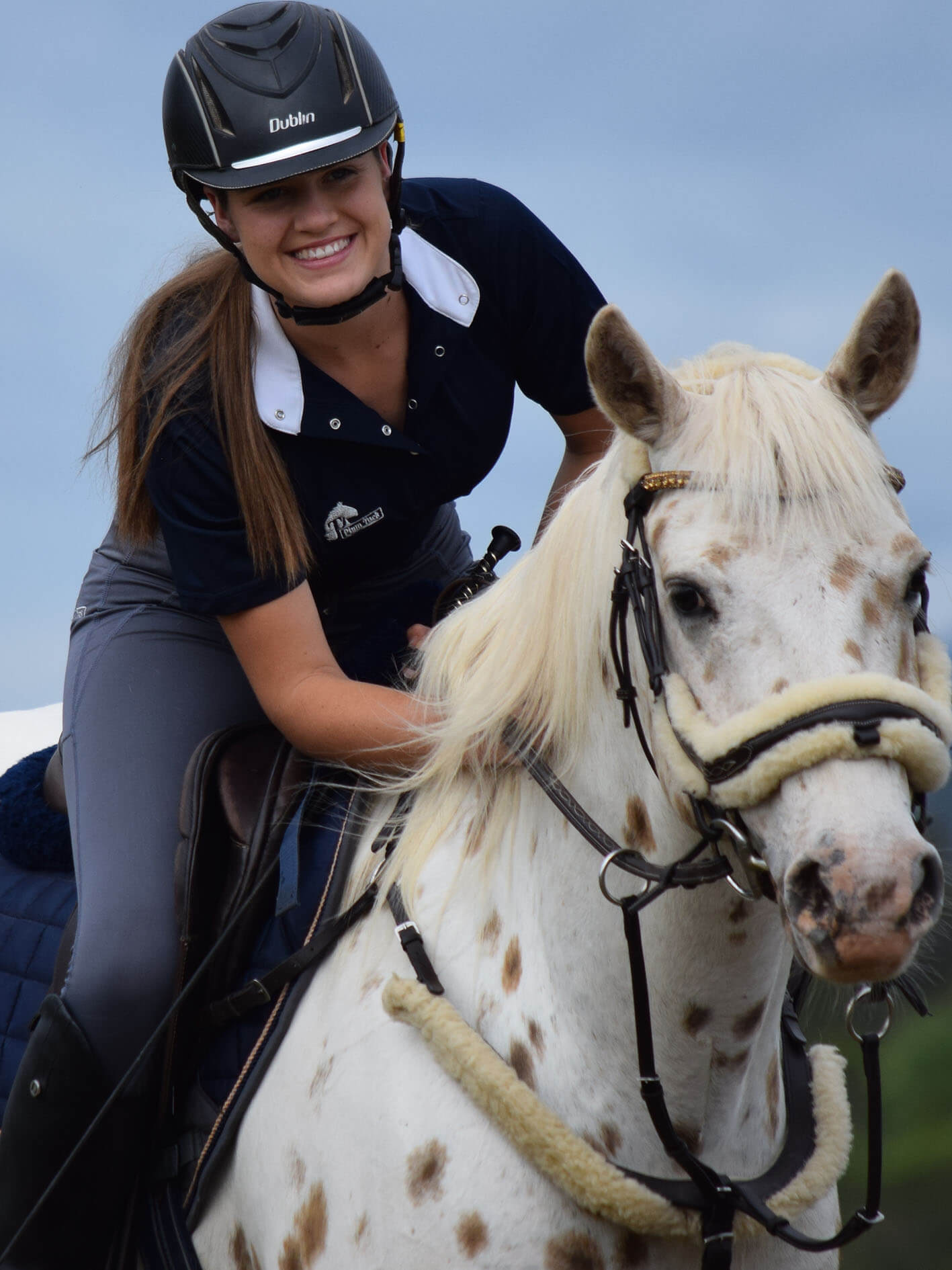 Woman riding horse with show shirt open for casual look