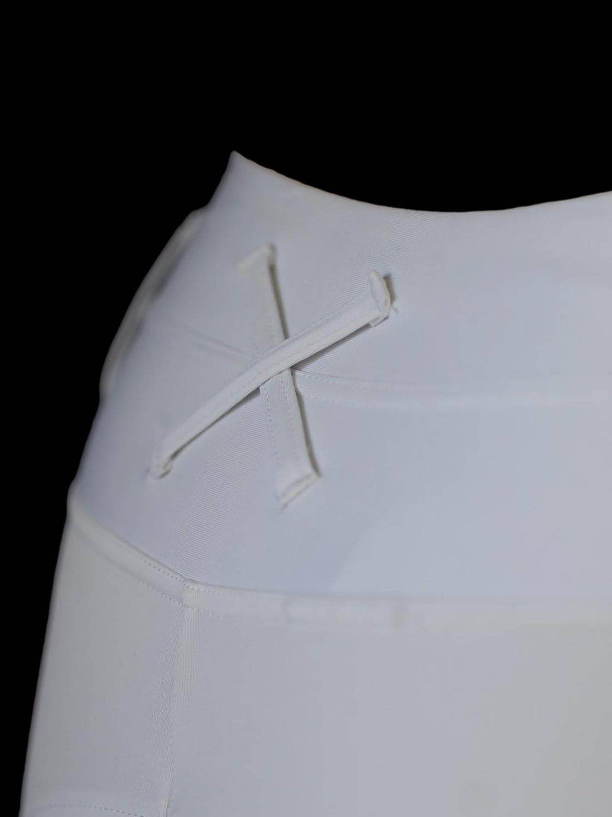 White dressage pants showing extreme close up of back of waistband and cross over belt loop detail 